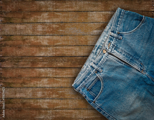 Denim jeans on grunge wooden background.