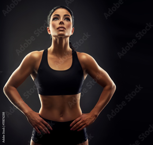 Beautiful fitness woman lifting dumbbells . Fitness sporty woman showing her well trained body . A beautiful girl's body with rippling muscles from strength training .