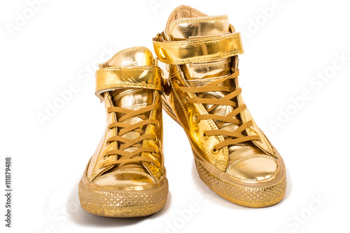 Pair of golden sneakers isolated