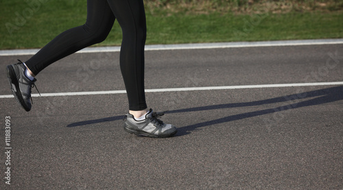 Shallow depth of field, toned with instagram like filter, flare effect. Closeup of female in running shoes going for run on road at sunrise or sunset.