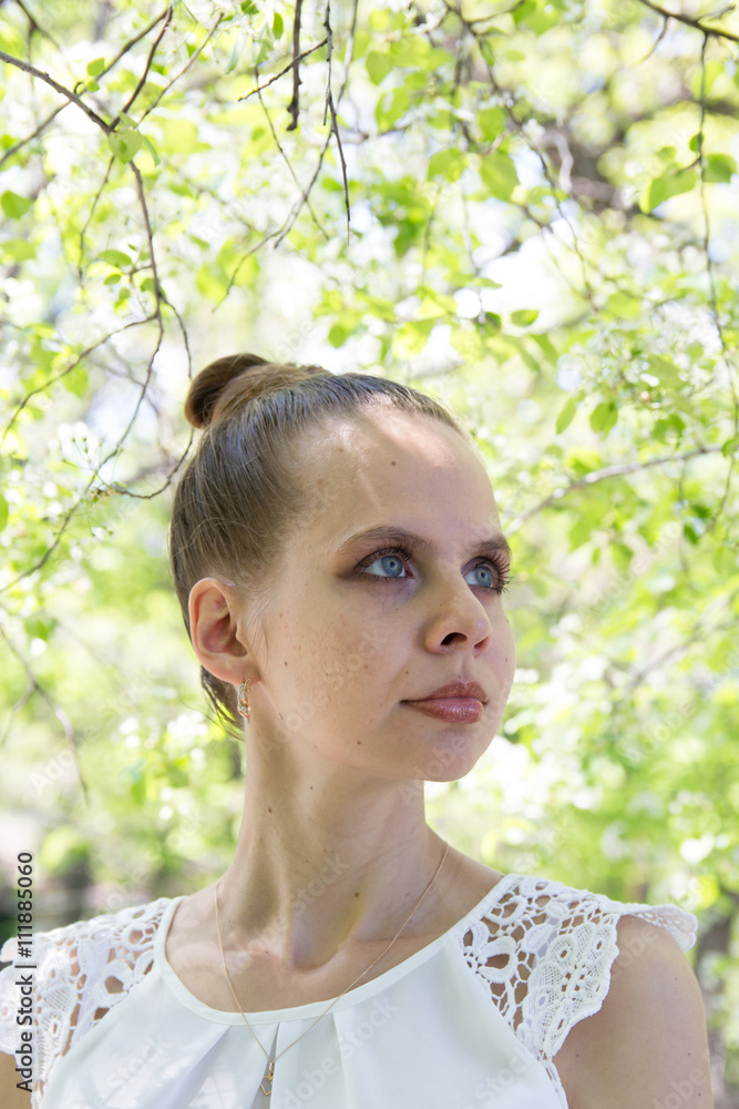 Portrait of a beautiful young girl on a background of flowering trees Portrait of a beautiful young girl on a background of flowering trees