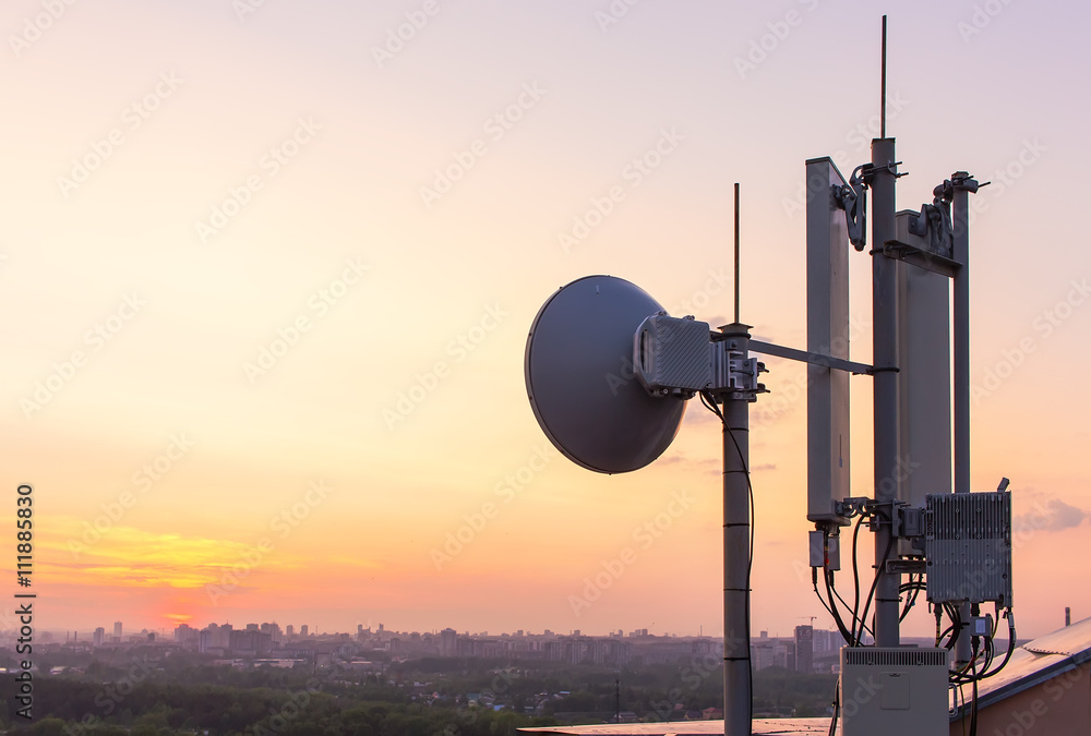 cellular communications tower on a background of the city and a beautiful sunset in summer cellular communications tower on a background of the city and a beautiful sunset in summer