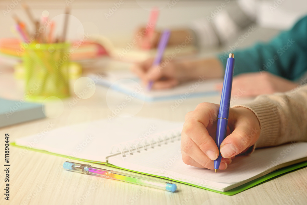 Students hands with pen writing on notebook Students hands with pen writing on notebook