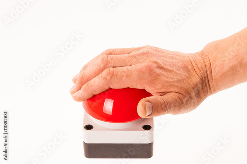 Hand pushing a red buzzer