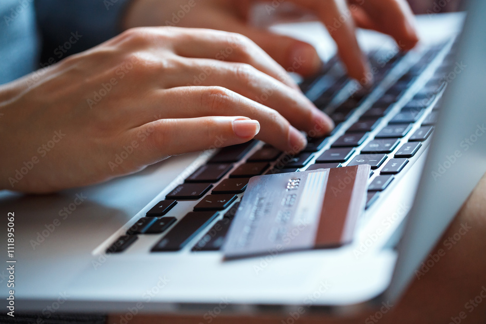 Hands using laptop and credit card on it