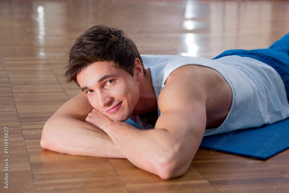 Young man doing sit ups in the fitness studio