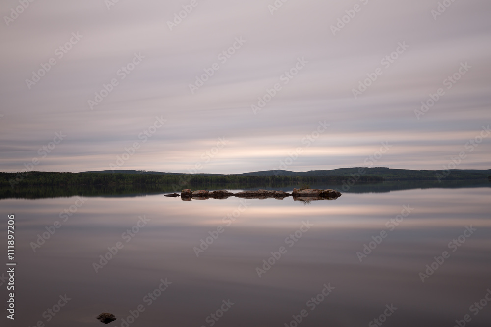 A calm lake in sweden early cloudy morning