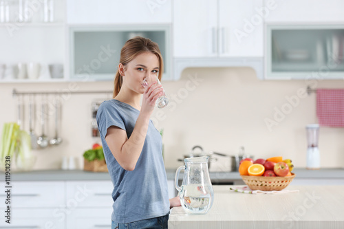 Young woman drinking water ...