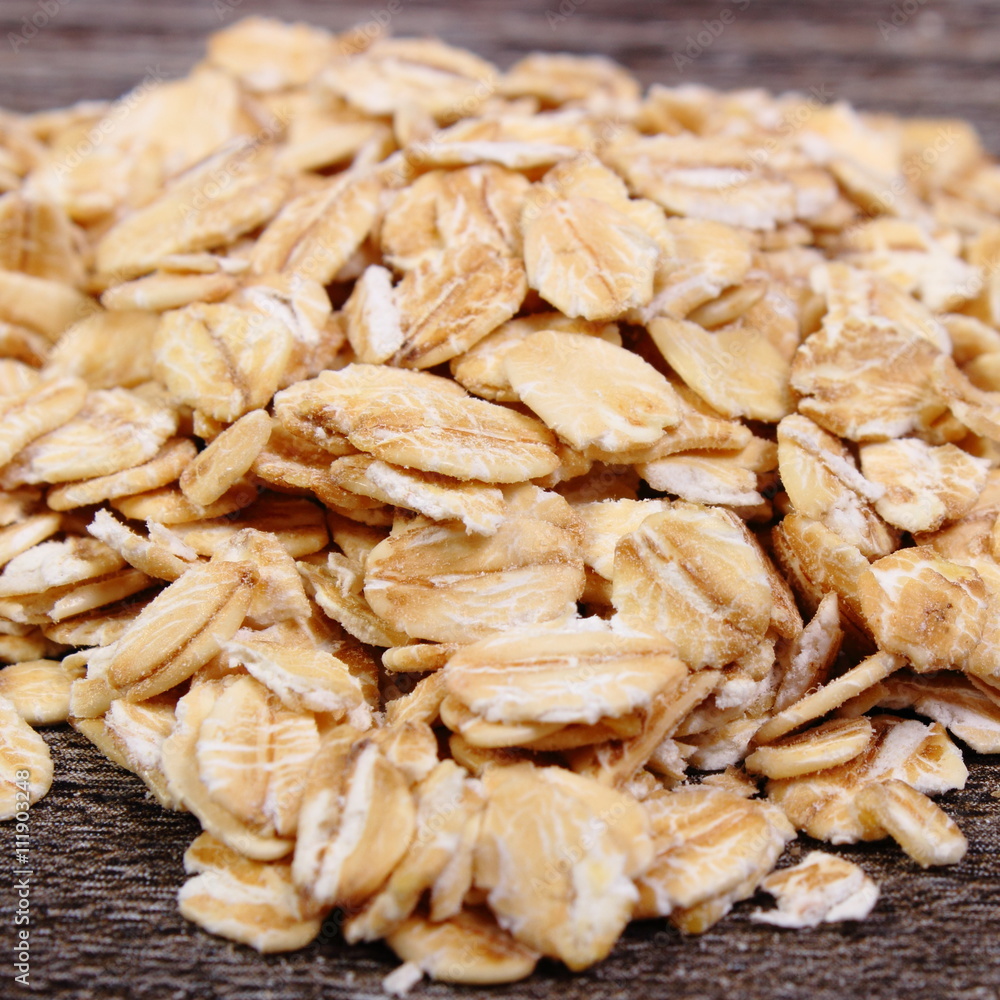 Heap of oat flakes on wooden background Heap of oat flakes on wooden background