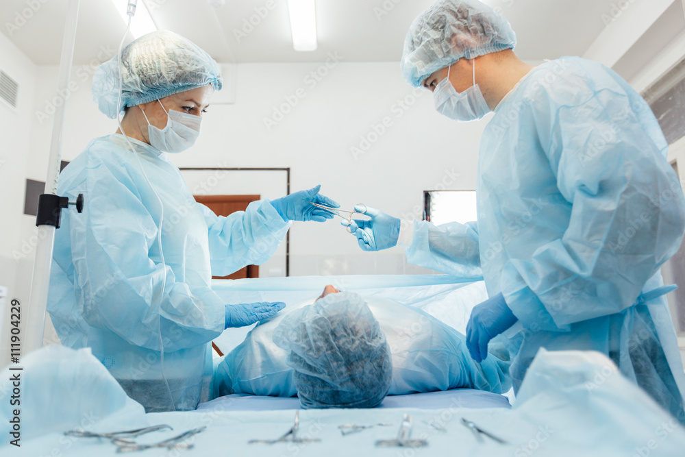 Surgeons team working with Monitoring of patient in surgical operating room. breast augmentation. Surgeons team working with Monitoring of patient in surgical operating room. breast augmentation.