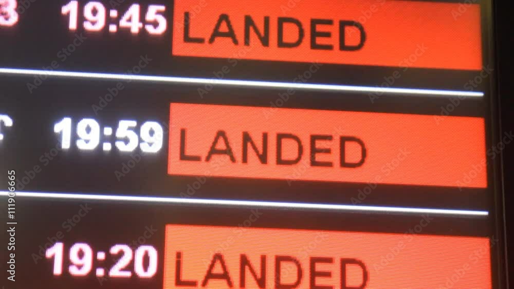 Flight laned on information board in airport terminal, selective focus.