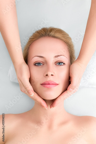 Young woman in spa gets a facial massage
