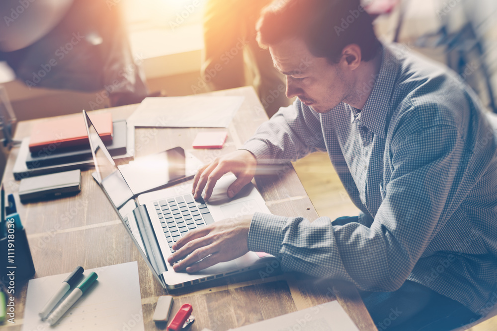 Man working with laptop. Open space office. Casual dress code. Blurry background, film effect Man working with laptop. Open space office. Casual dress code. Blurry background, film effect