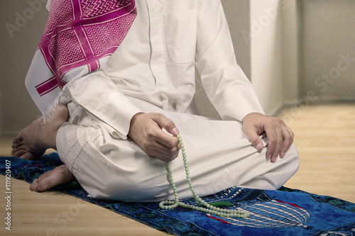Muslim man dhikr with beads at home photo