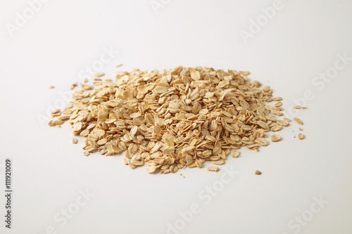 Healthy diet rolled oats isolated on white in center, prepared for cooking muesli for breakfast, side close focus view