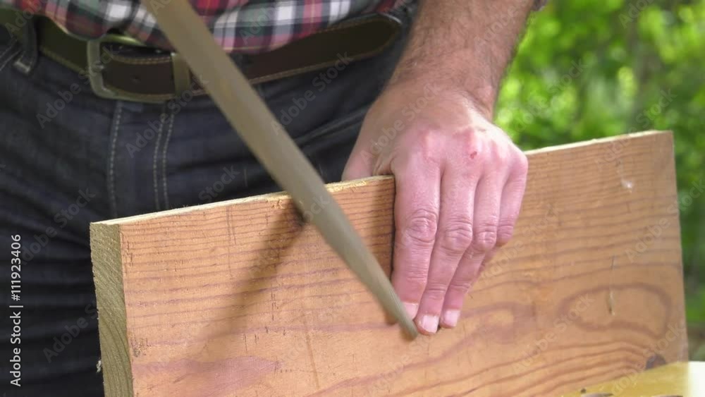 Using a wood rasp on the edge of a board Using a wood rasp on the edge of a board