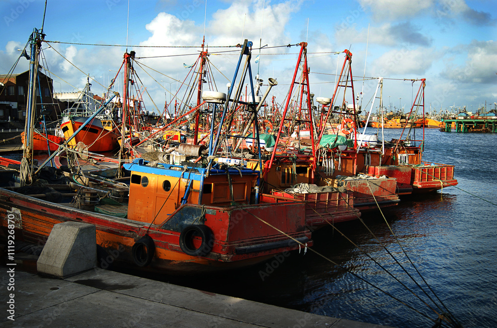 Fototapeta premium Typical orange fishing boats on the port of the coastal city of Mar del Plata, Argentina.