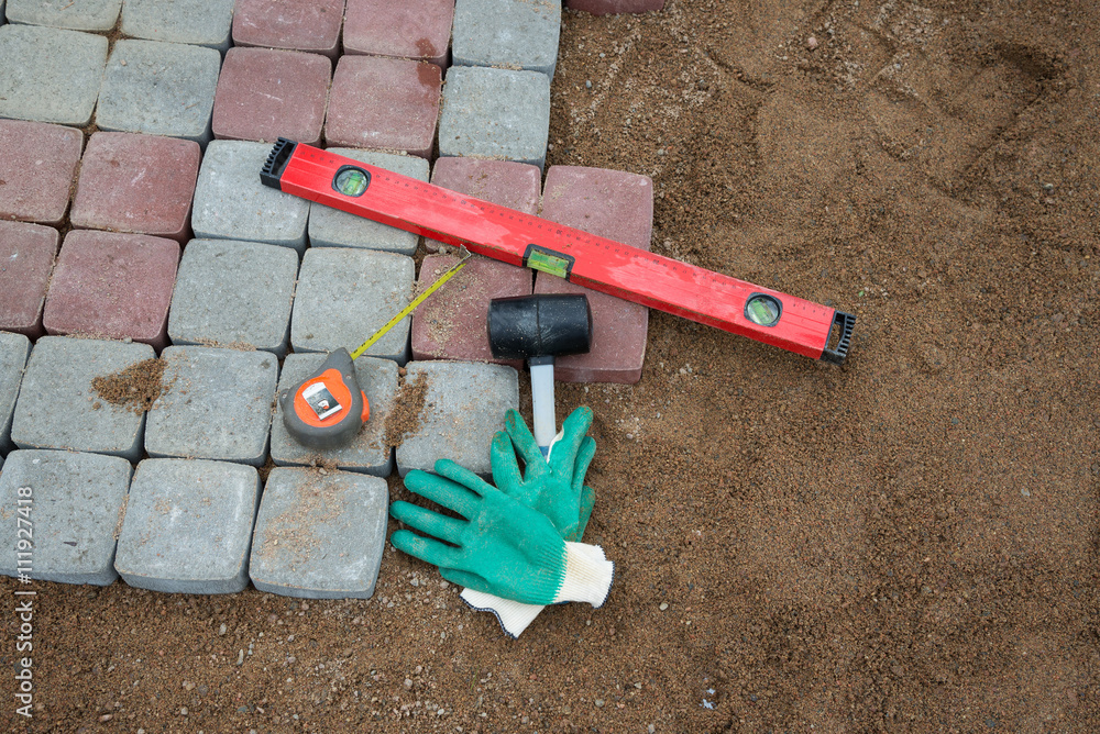 , stone blocks rubber hammer level gloves and tape measure , stone blocks rubber hammer level gloves and tape measure