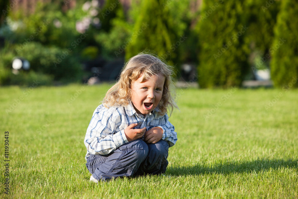happy boy sitting on the green grass in sunny day happy boy sitting on the green grass in sunny day