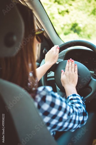 Woman hand pressing on a car horn photo