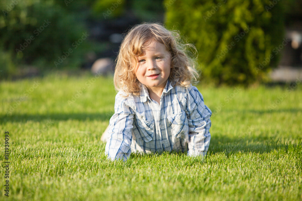cute boy lying on the green grass in sunny day
cute boy lying on the green grass in sunny day