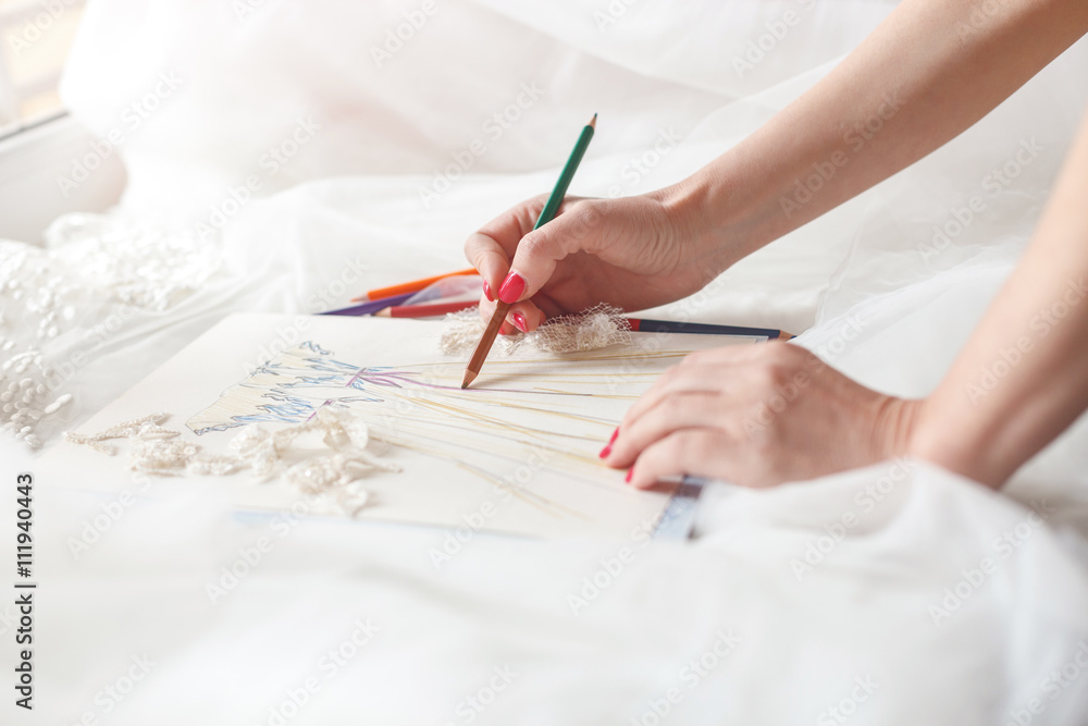 Naklejka premium Cheerful female tailor is creating bridal gown
