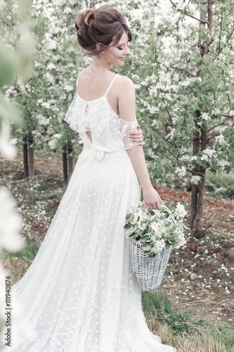 beautiful sweet gentle happy girl in a beige boudoir dress with flowers in a basket holding , photo processing in the style of modern fine art