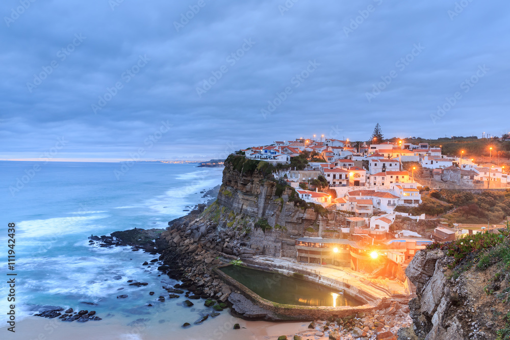 Azenhas do Mar village at dusk with stormy sea and dark clouds,