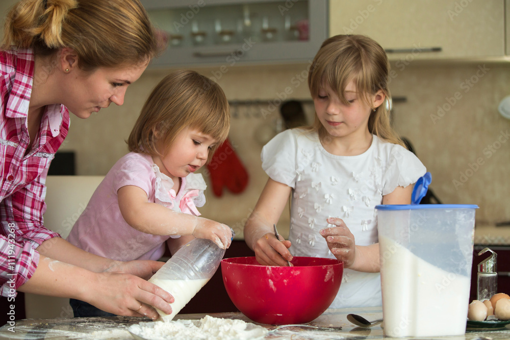 baby girls, Mom. child 2 years of a child 7 years old and their mother preparing breakfast in the kitchen. baby girls, Mom. child 2 years of a child 7 years old and their mother preparing breakfast in the kitchen.