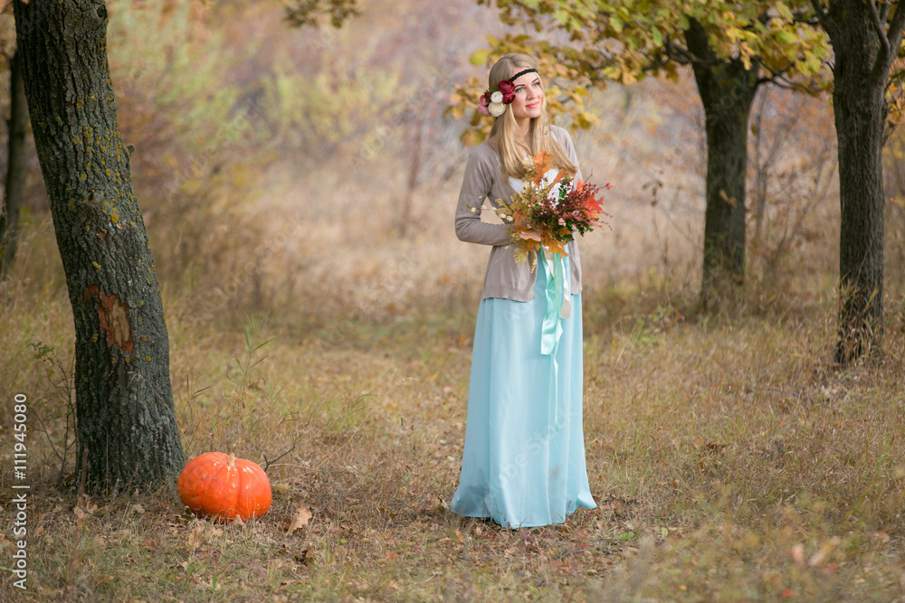 Autumn wedding in boho style. Autumn leaf fall, autumnal forest. Girl with a bouquet of autumn leaves and berries. Thanksgiving Day Autumn wedding in boho style. Autumn leaf fall, autumnal forest. Girl with a bouquet of autumn leaves and berries. Thanksgiving Day