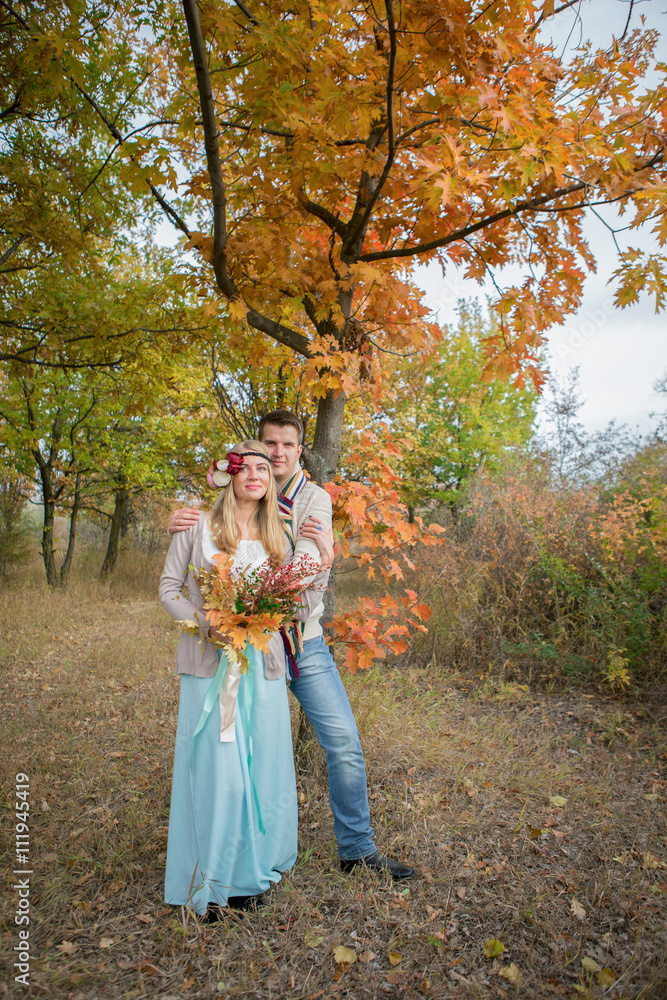 Autumn wedding in boho style. Lostopad autumn, autumn park. Girl with a bouquet of autumn leaves and berries.