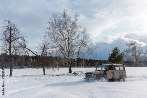 old SUV driving on a snowy field