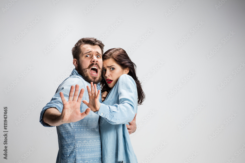 Close up Shocked Young Couple with Mouth and Eyes Wide Open Looking at Camera on gray Background. Close up Shocked Young Couple with Mouth and Eyes Wide Open Looking at Camera on gray Background.