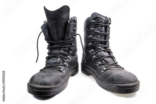 Pair of old military shoes/Old dirty army boots made of black leather on white background