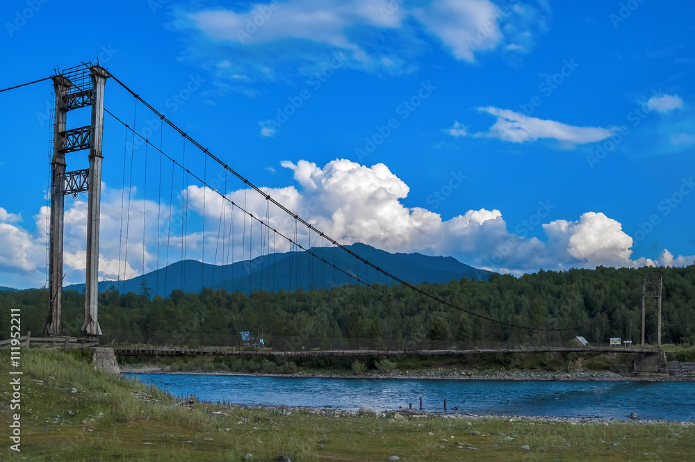 Tyungur, Russia - July 23, 2005: Suspension road bridge on the river Katun. Altai Mountains