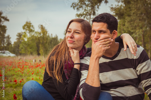 Young couple looking away with a thoughtful look while sitting o