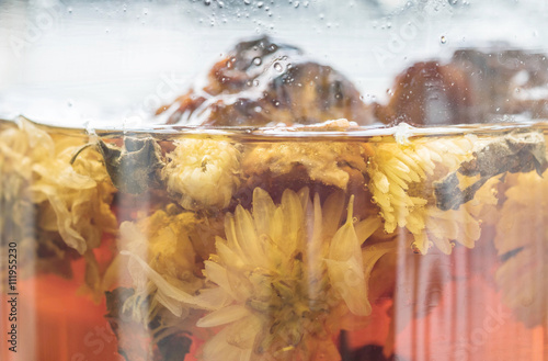 Fototapeta Naklejka Na Ścianę i Meble -  Closeup hot herbal drinks in glass jar textured background