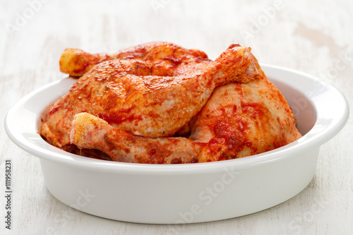 Fotografia marinated chicken in white dish on white woooden background