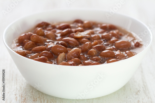 boiled beans in white dish on white wooden background