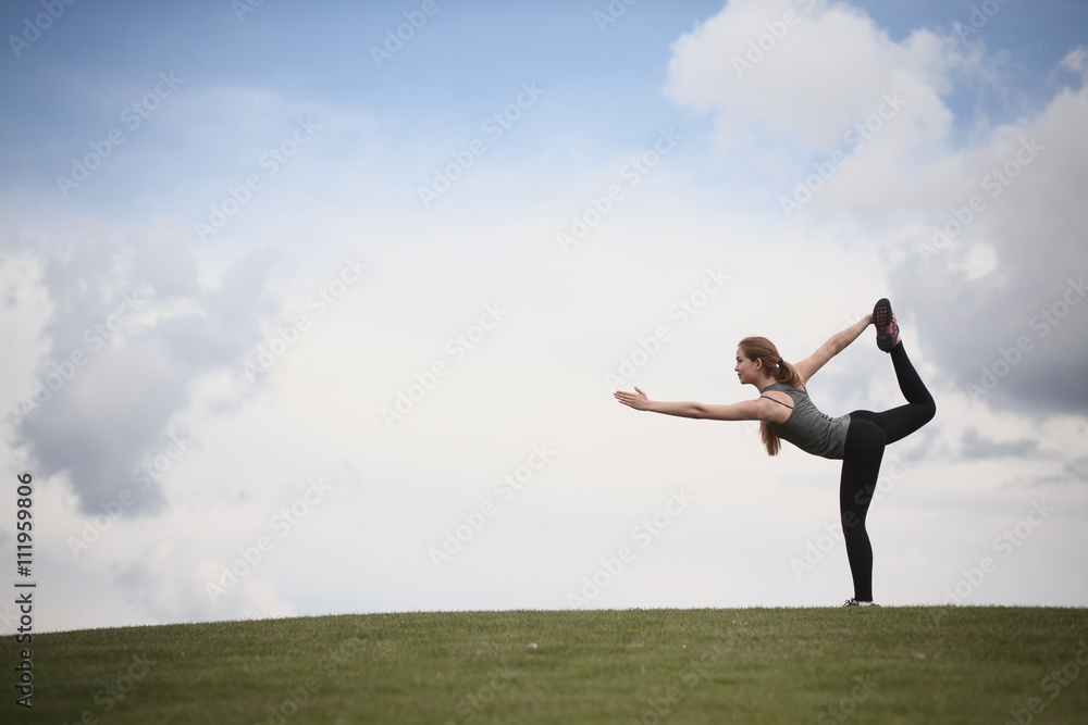 Yoga woman in park. Woman training in urban park at sunset intentional sun glare. Photo of sporty woman doing yoga with nature. Yoga woman in park. Woman training in urban park at sunset intentional sun glare. Photo of sporty woman doing yoga with nature.