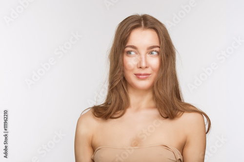 Portrait of beautiful model lady with perfect makeup over white background in studio. Pretty woman looking away and smiling for camera. Studio shot.