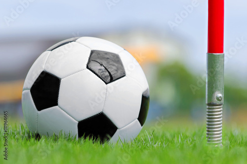 Soccer ball on football green field on the corner