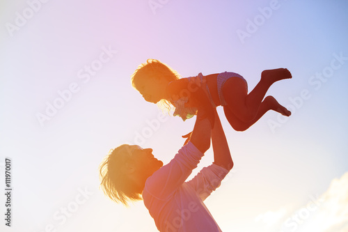 Father and little daughter silhouettes at sunset