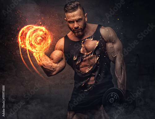 Portrait of bodybuilder with burning dumbbell. photo