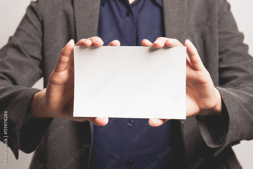 Young businesswoman holding business blank card. Young businesswoman holding business blank card.