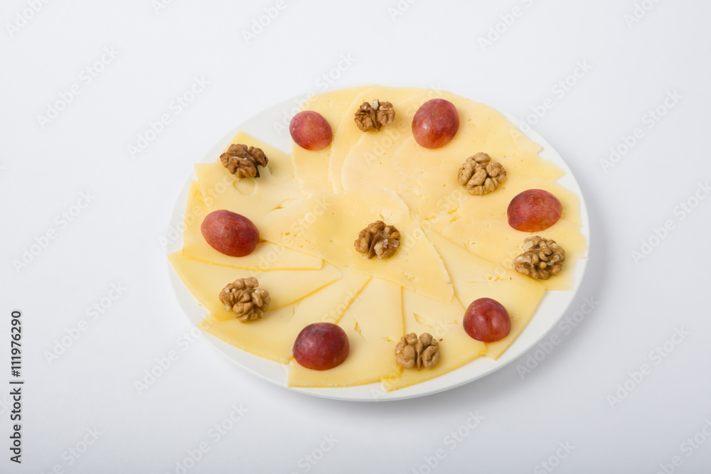 Cheese sliced with nuts and grapes