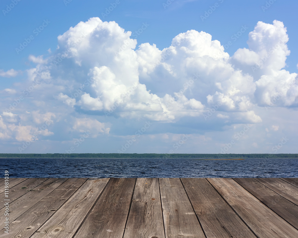 Empty wooden deck on the background of sea and sky with clouds. Empty wooden deck on the background of sea and sky with clouds.