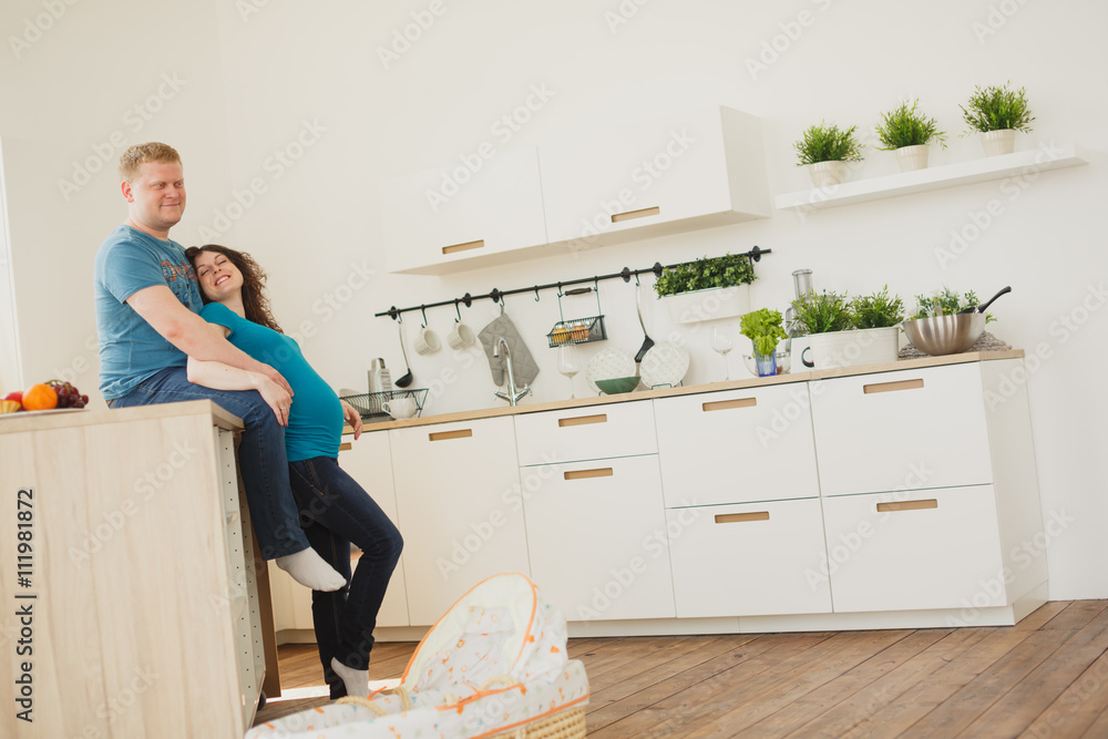 Happy pregnant couple of vegetarians in the kitchen. Happy pregnant couple of vegetarians in the kitchen.