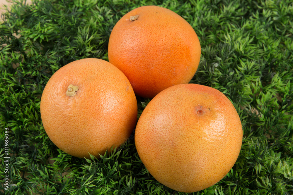 Tasty grapefruit isolated on the green background Tasty grapefruit isolated on the green background
