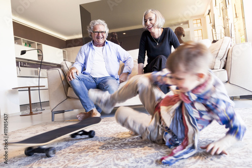 Fotografie couple of happy grandparents are fun nephew with skateboard